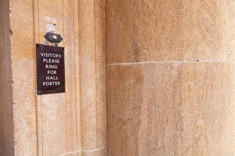 Visitors please ring for hall porter' sign by door bell button