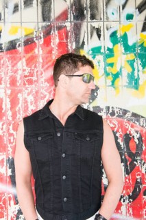 Man standing in front of wall covered with graffiti