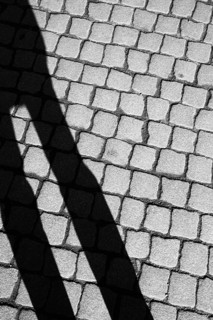 Shadow of a person on cobbled street