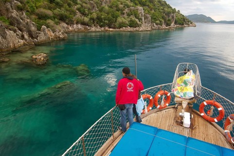 Tourists on yacht looking at the ruins of the sunken city of Kekova