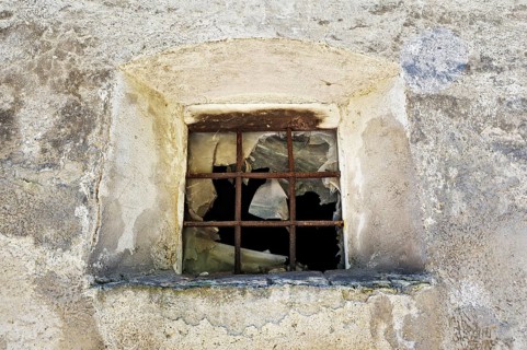 Old broken window with iron bars