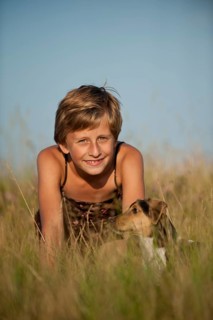 Girl sitting with a Dansk-Svensk Gardshund or Danish Swedish Farmdog in a meadow