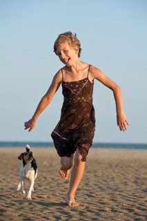 Girl running with a Dansk-Svensk Gardshund or Danish-Swedish Farmdog on the beach