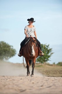 Woman riding a trotting Quarter Horse