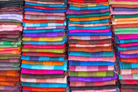 Colourful silk textiles on display at a market stall in Luang Prabang