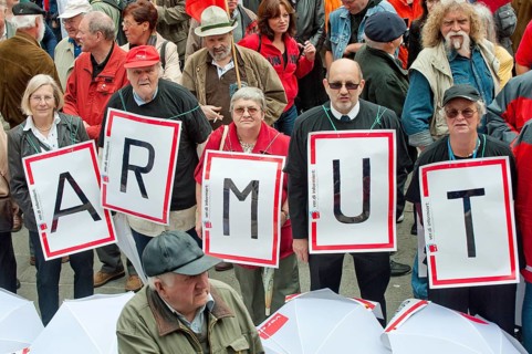 Senior citizens holding protest posters spelling out the word 'Armut'