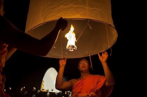 Monks releasing a Kongming lantern or sky lantern for luck during the Loi Krathong or Loy Gratong Festival