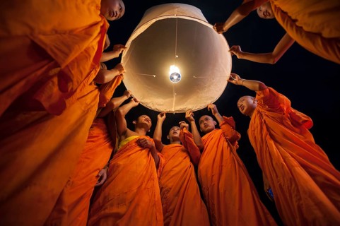 Monks releasing a Kongming lantern or sky lantern for luck during the Loi Krathong or Loy Gratong Festival