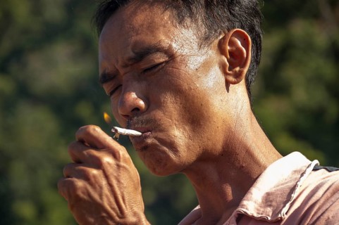 Man from the Shan or Thai Yai ethnic minority is lighting a cigarette