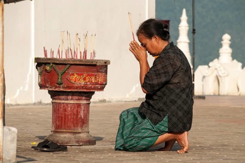 Woman in prayer holding incense sticks