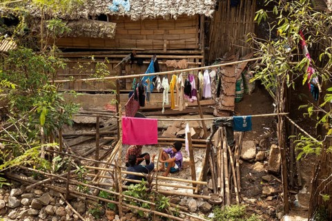 Young people sitting outside a hut