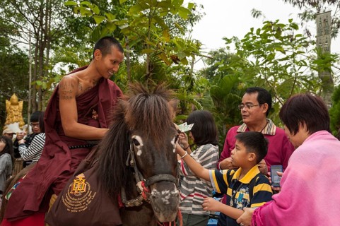 Buddhist monk on horseback collecting alms in the morning