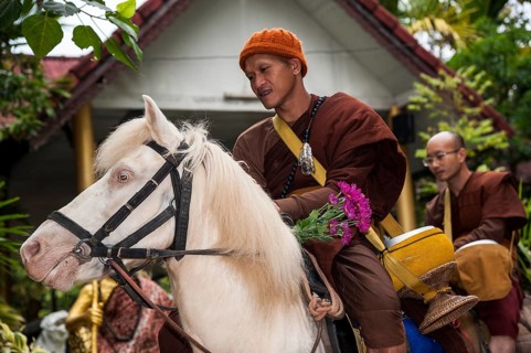 Buddhist monk on horseback collecting alms in the morning