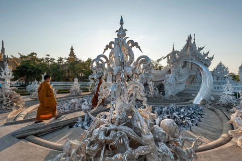 Buddhist monk walking across a bridge