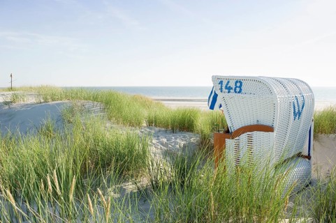 Dunes and white roofed wicker beach chair
