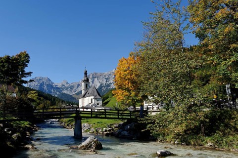 Parish Church of Saint Sebastian and the Ramsau river in front of the Reiteralpe or Reiter Alm mountains