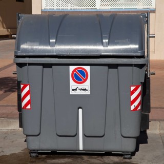 Wheeled trash can with a No parking sign standing on the roadside