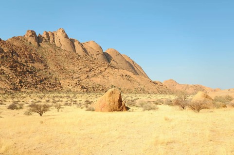 Savannah landscape with granite rocks and Spitzkoppe Mountain