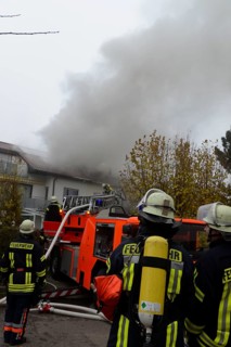 Firefighters wearing breathing equipment while extinguishing a roof fire