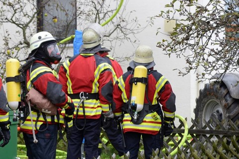 Firefighters wearing breathing equipment while extinguishing a roof fire