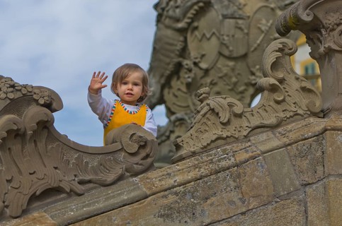 Little girl at the stone sculptures in the park around Schloss Seehof palace