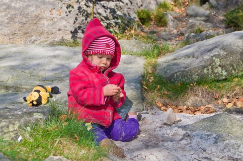Little girl playing between rocks in the sand