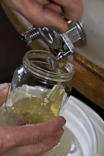 Filling a jar of honey from a storage drum