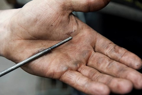 Checking oil level in tractor engine using dipstick