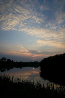 View of cirrocumulus clouds over flooded former gravel pit habitat at sunset