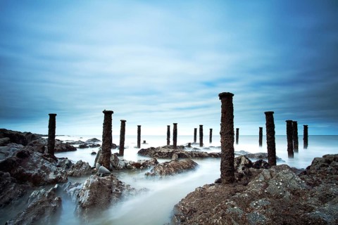 Steel stantions of ruined Victorian pier visable on shore at low tide