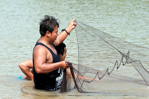 Fishermen putting out a fishing net in the Sangkae river