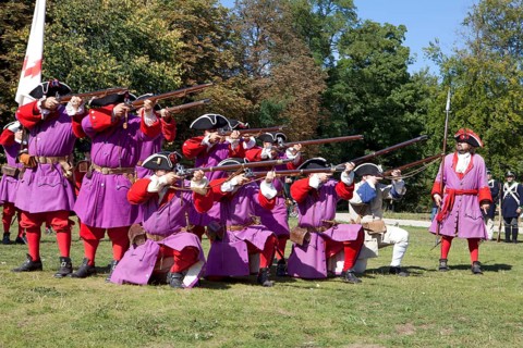 Soldiers with muzzle-loading rifles shooting during live role-playing or ReenLarpment