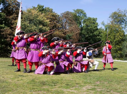 Soldiers with muzzle-loading rifles shooting during live role-playing or ReenLarpment