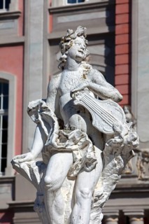 Baroque statue holding a musical instrument in front of the Electoral Palace in Trier
