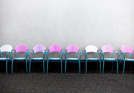 A row of pink chairs in front of an Italian ice cream parlor