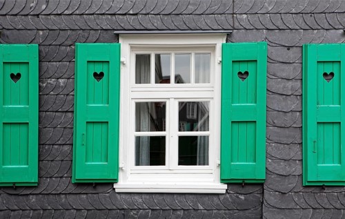 House front with slate and with a heart in the shutters
