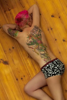 Woman with tattoos on arm and back