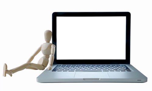 Manikin leaning against a laptop computer