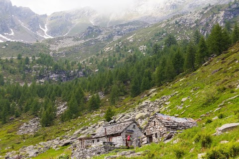 Man arriving at a few mountain huts while hiking