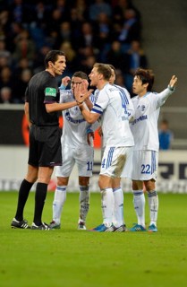 Schalke 04 players arguing with the referee Deniz Aytekin