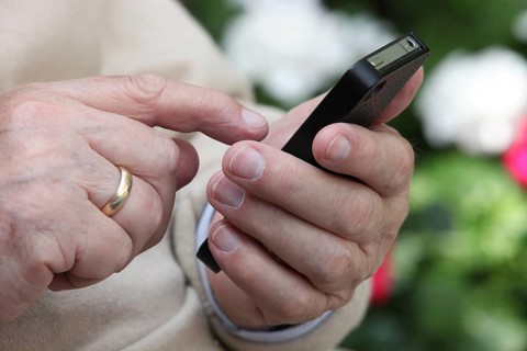 Elderly man holding a smartphone in his hand