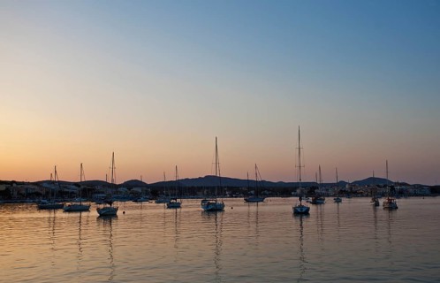 Sailing boats in a harbour at sunset