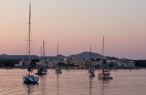 Sailing boats in a harbour at sunset
