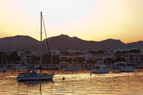 Sailing boats in a harbour at sunset