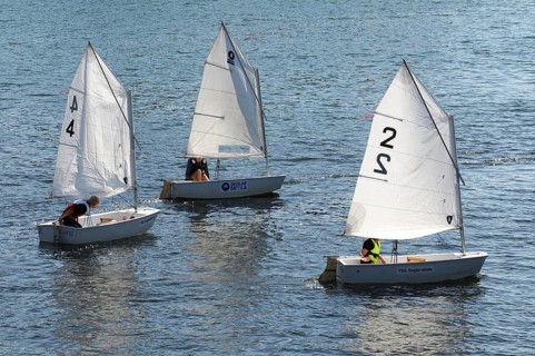 Three Optimist dinghies in a sailing school