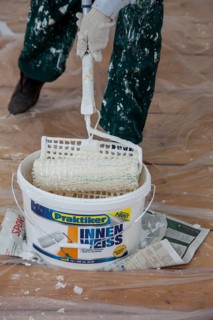 Bucket of paint and a paint roller for painting the walls