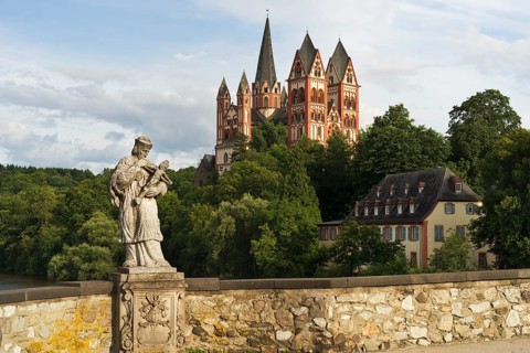 The statue of St. Nepomuk on the Alte Lahnbrucke bridge with the late Romanesque and early Gothic Limburg Cathedral of Sankt Georg