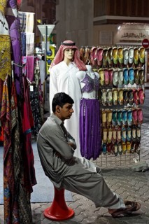 Salesman sitting bored in front of his shop