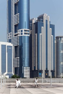 Workers cleaning a terrace in front of skyscrapers with a high pressure washer