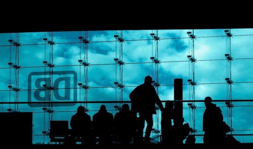 Silhouettes of travellers waiting for trains in the main station building